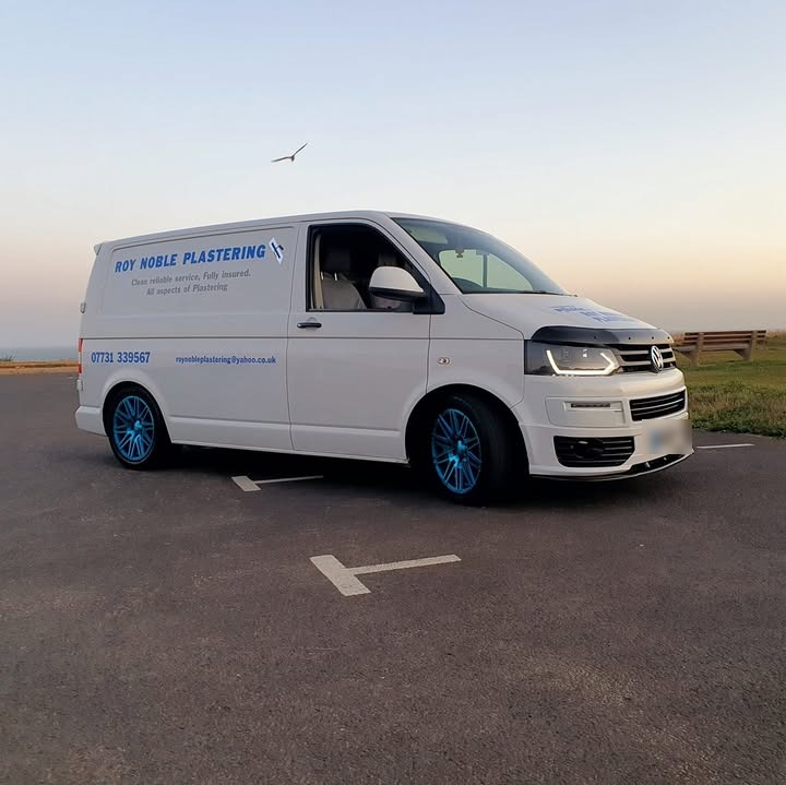Roy Noble Plastering's white van, lettered in blue, parked on the clifftop at dusk